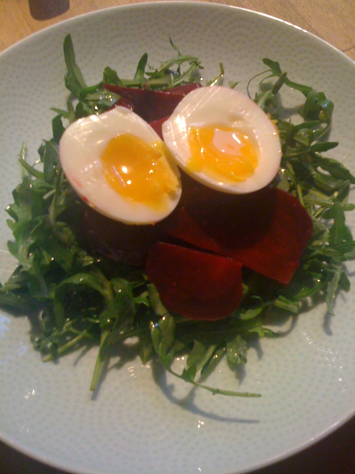 Beet Salad tossed in an Anchovy Infused Balsamic Dressing, served on a Bed of Baby Arugula and topped with a Farm Fresh Soft Boiled Egg